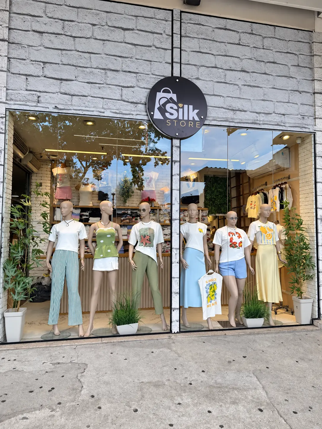 Vitrine da Silk Store com manequins e roupas femininas