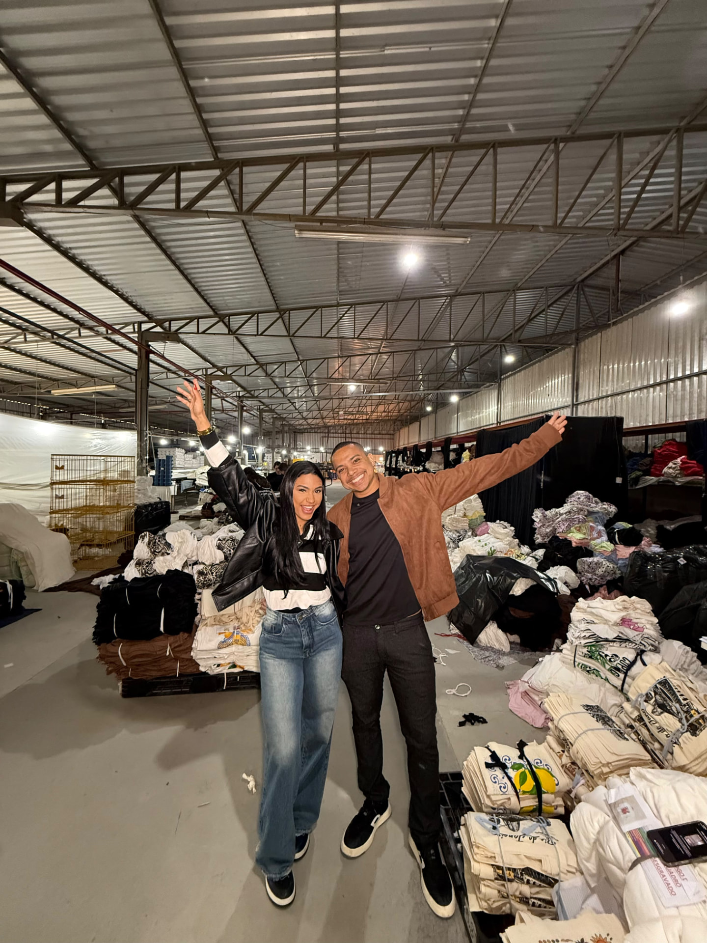 Tom e Raquel juntos dentro da operação, cercados por produtos e pela estrutura do negócio